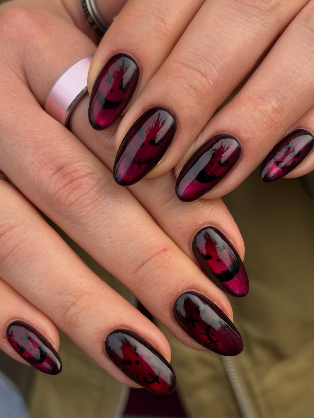 Amandelvormige nagels in glanzend donkerrood met zwarte vleermuizen