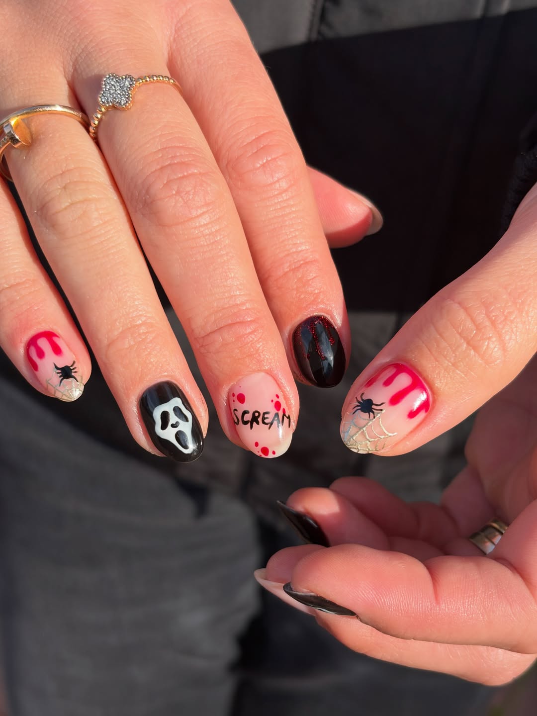 Korte nagels met een Halloween-design: spookmasker, spinnenweb en het woord Scream