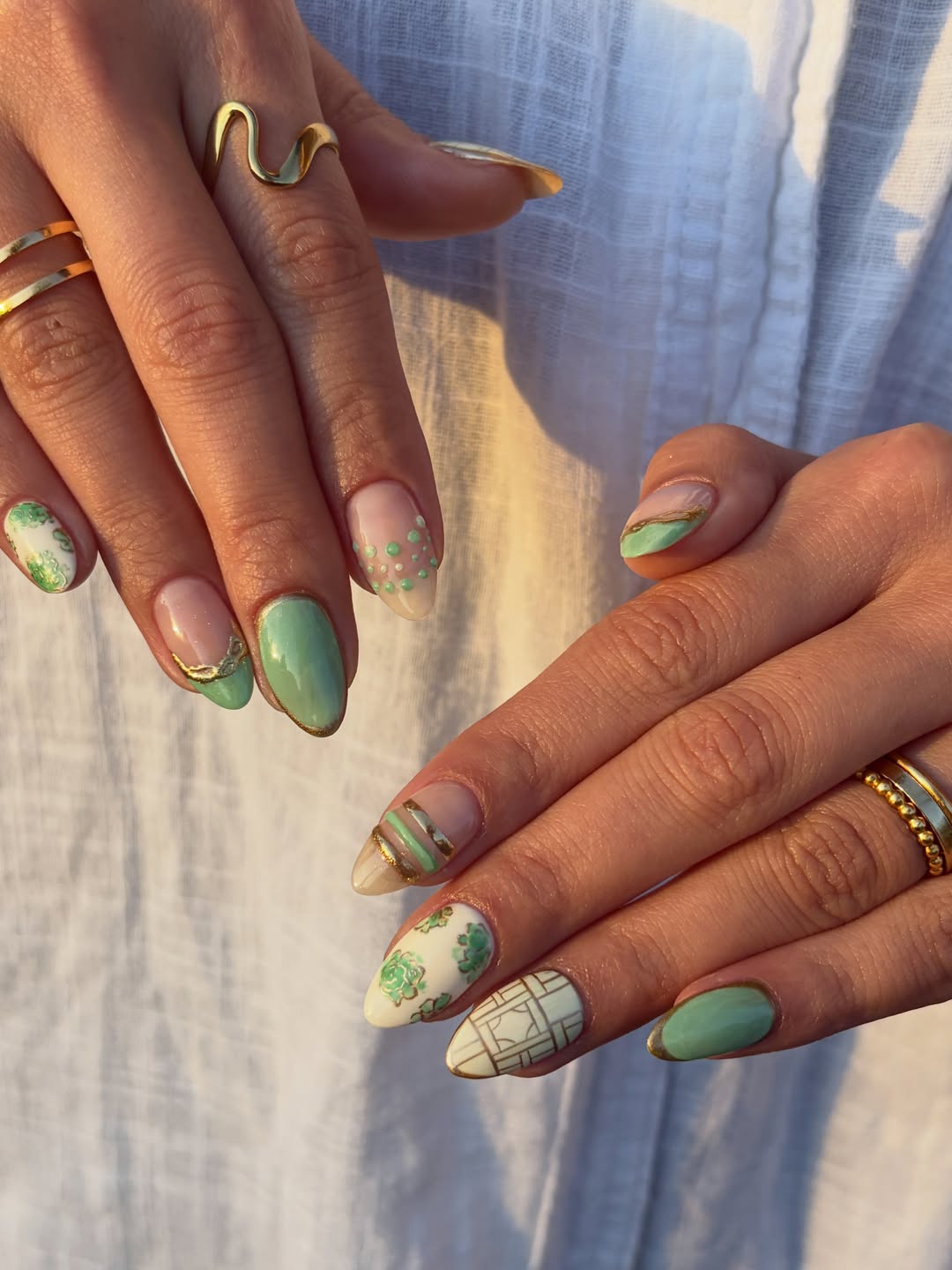 Lichte nagels met saliegroene designs en een patroon